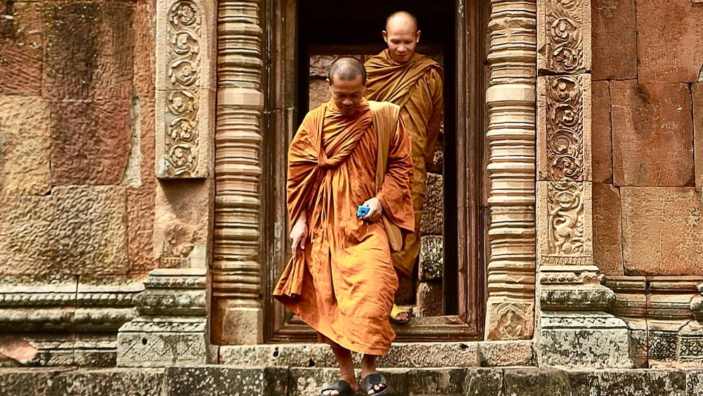 Buddhistische Mönche verlassen einen Tempel in Thailand; mit lokaler SIM-Karte oder eSIM erreichbar bleiben