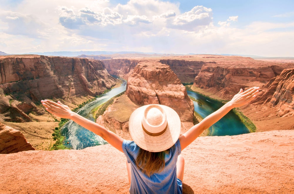 Vrouw met hoed geniet van uitzicht over Horseshoe Bend tijdens rondreis door Amerika met simkaart USA