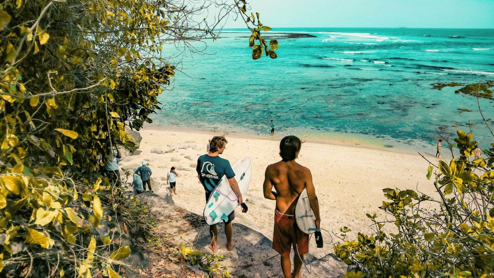 Surfers lopen naar het strand op Bali; geniet van snel mobiel internet in Indonesië