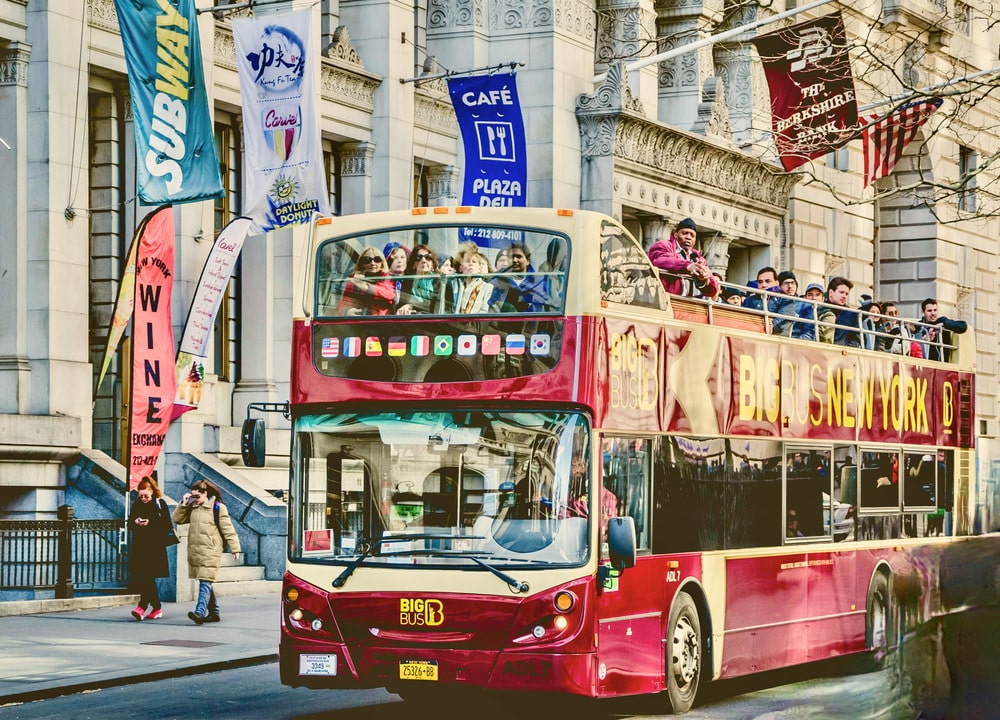 Hop-on-hop-off sightseeing bus in New York City met toeristen tijdens stedentrip in Amerika