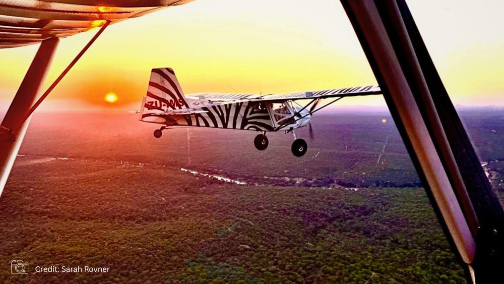 Klein vliegtuig boven Zuid-Afrika bij zonsondergang; reizen met lokale simkaart of eSIM