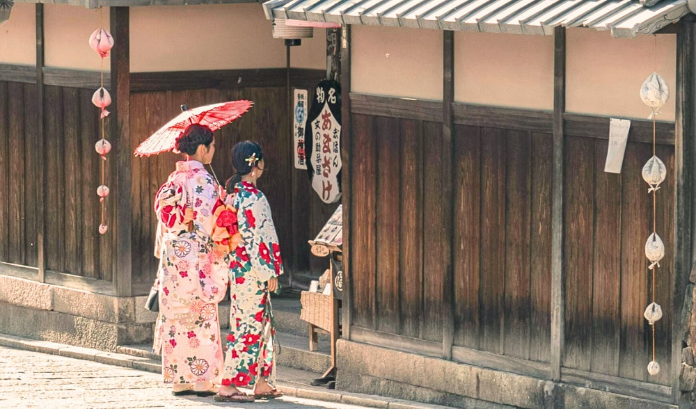Two women in kimono walking through a traditional Kyoto street; stay reachable in Japan with an eSIM or SIM card